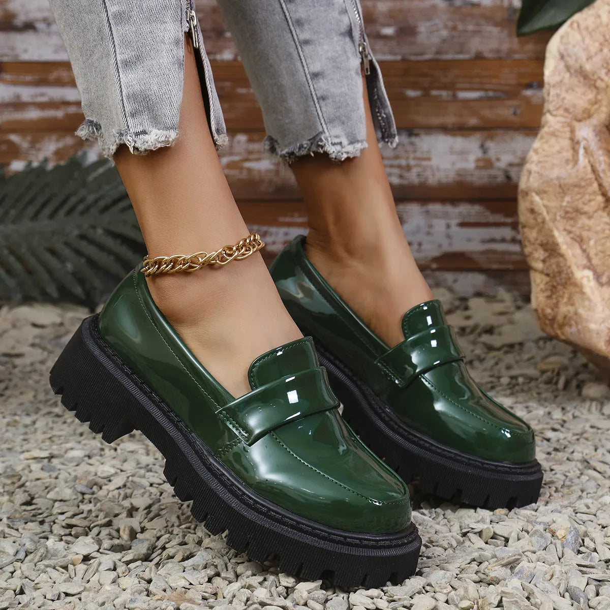 Women's black chunky heel slip-on loafers with a platform sole, shown on a foot.