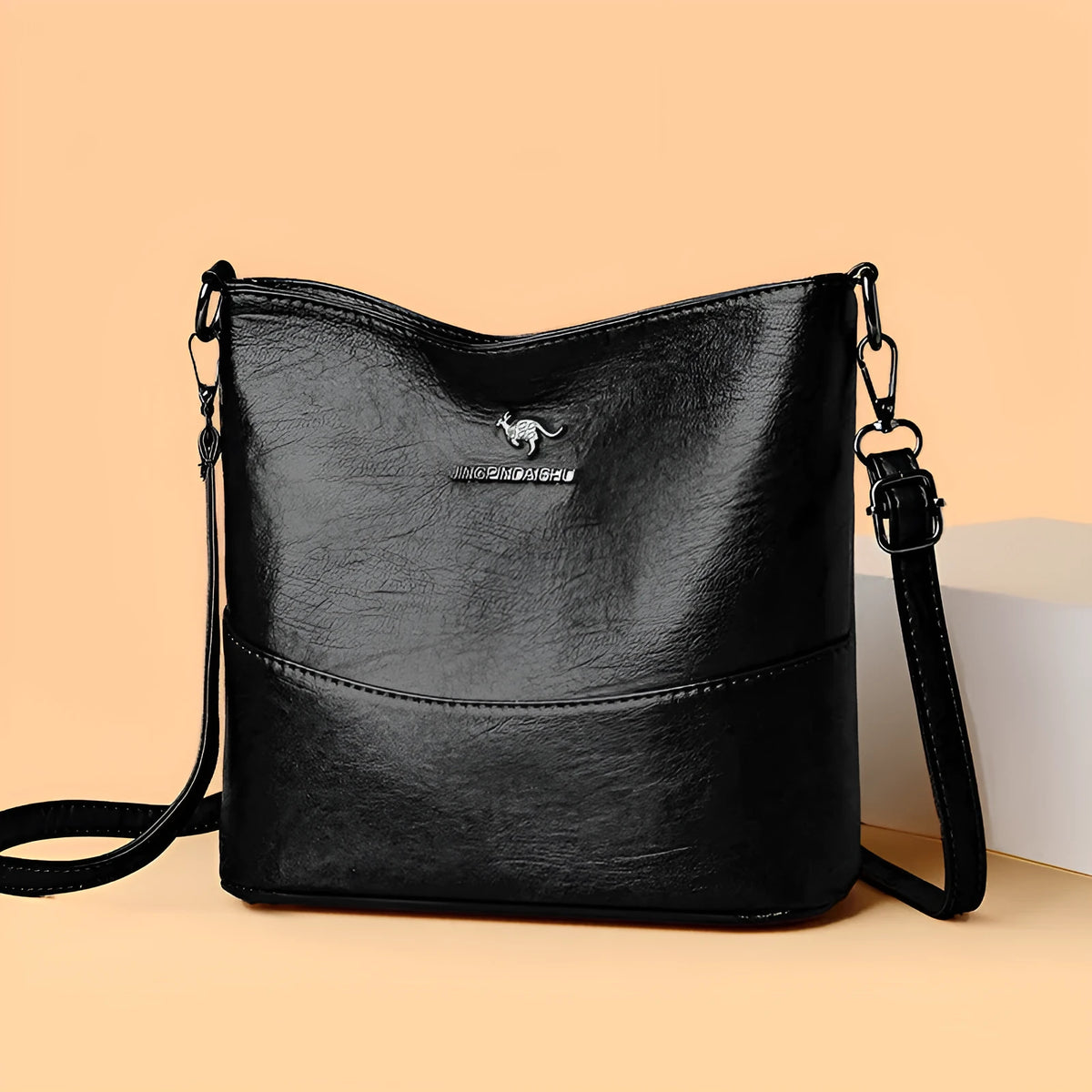 Women's solid colour soft leather bucket shoulder bag with sewing detail on strap, shown in ginger yellow.