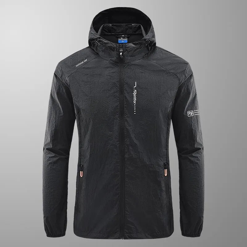Man wearing a lightweight grey hooded nylon summer jacket outdoors.
