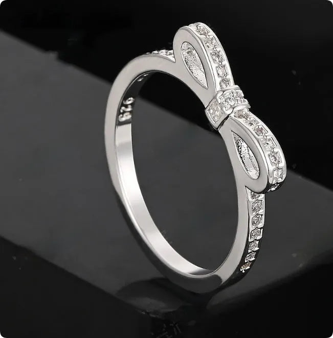 Silver bow ring with zircon crystal and rhinestone detailing on finger