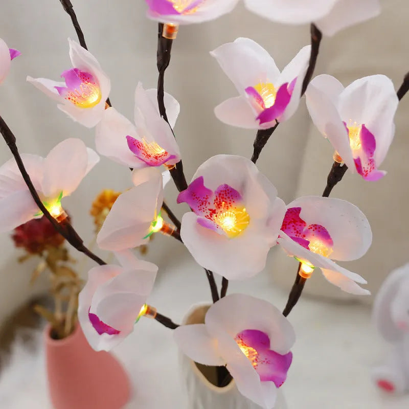Pink LED phalaenopsis orchid branch decorative light on a dark surface.
