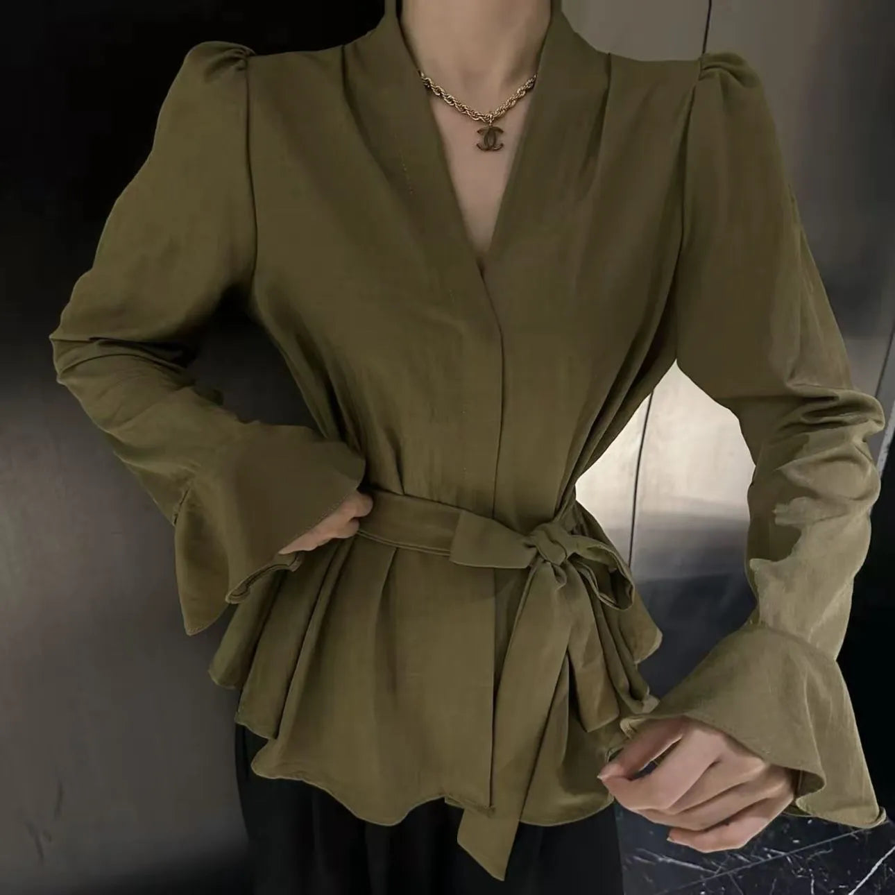 Women's black French-style shirt with irregular collar, tied front, and long bell sleeves.