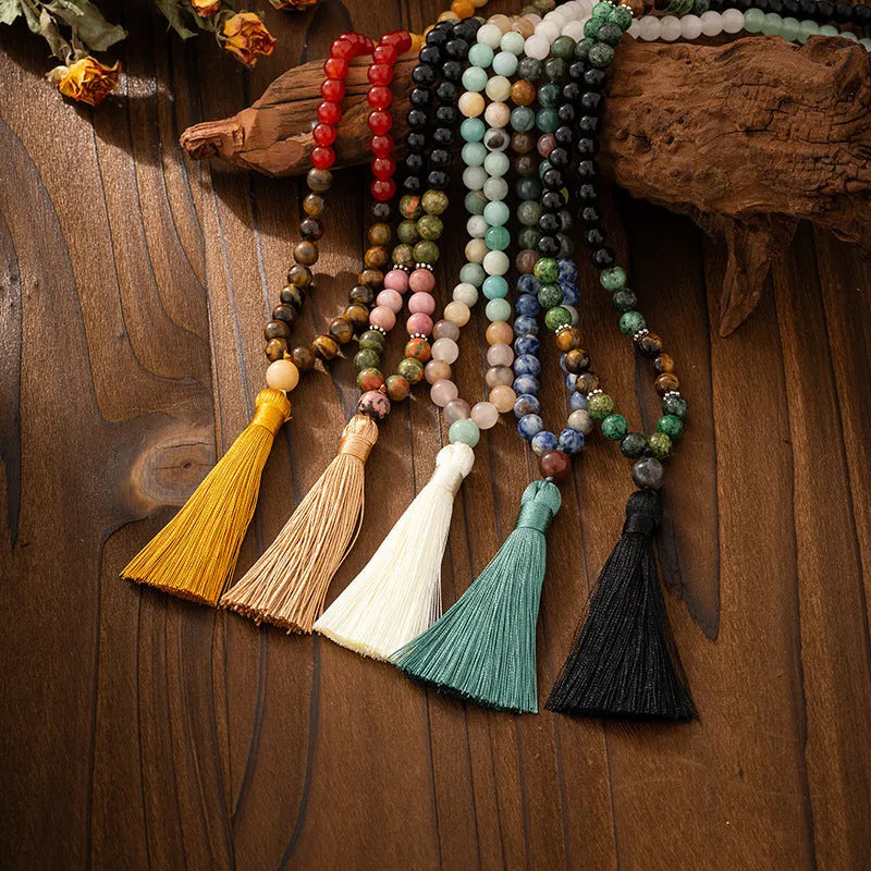 Bohemian-style long necklace chain with vintage tassel and matching bracelet on dark background