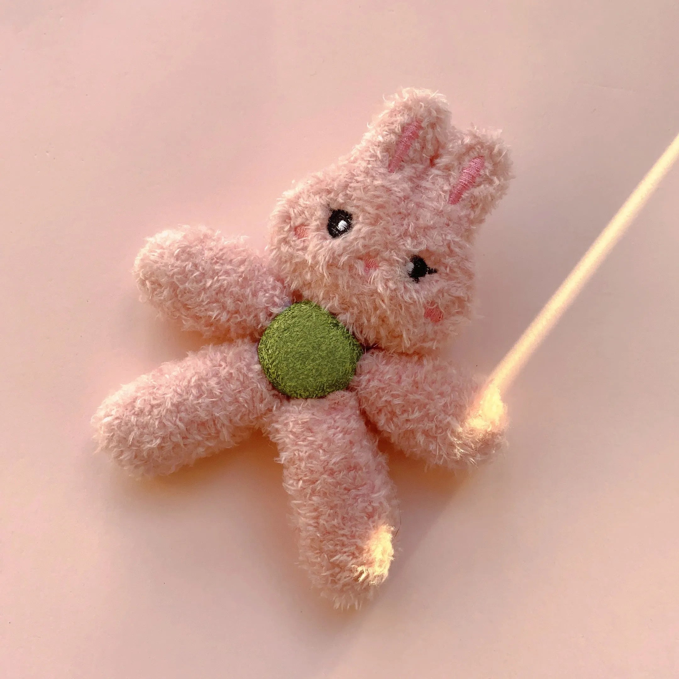 Brown bear shaped stuffed catnip ball edible chewing toy for cats on a white background.