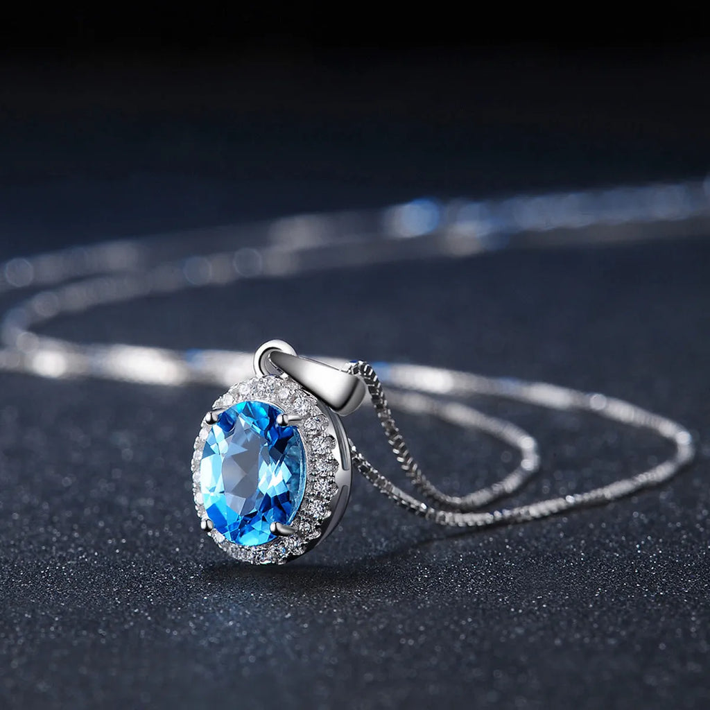 925 sterling silver jewellery set with blue topaz gems showing earrings, ring, pendant and necklace with geometric design