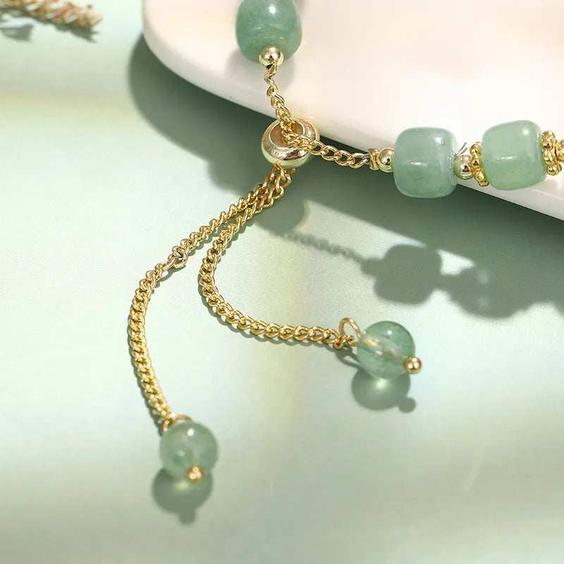 Women's rabbit charm bracelet with green aventurine stones and silver and gold plated metal links.