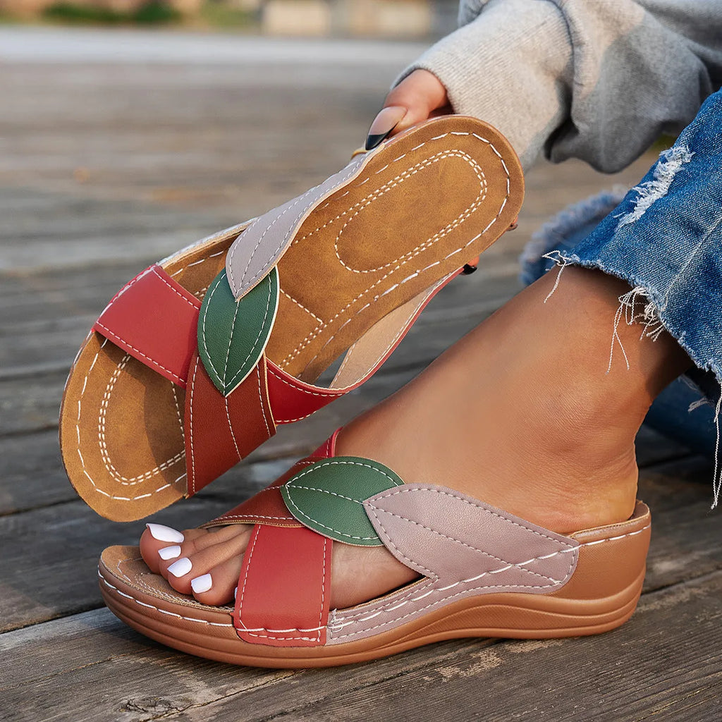 Black women's peep-toe slippers with a cross-strap design and a thick sole.