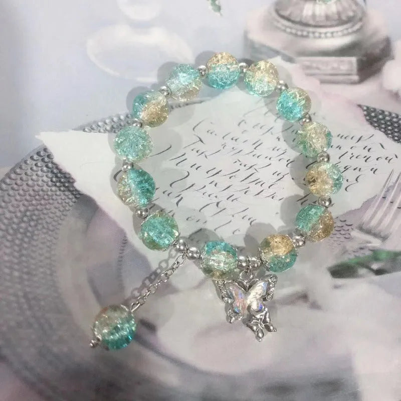 A Chinese style glass bracelet with bamboo leaf and bead designs on a wrist.