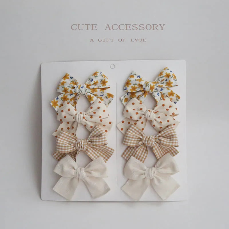 Set of eight fabric dovetail bow hairclips for children in various colours