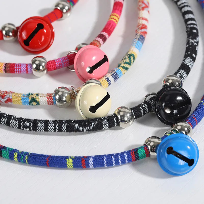 Coloured adjustable pet collar with ethnic embroidery and a metal bell, shown on a dog.