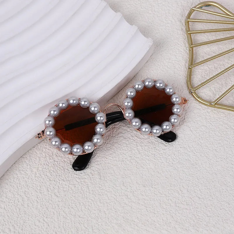Pearl-rimmed round sunglasses on a cat and dog for costume dress up