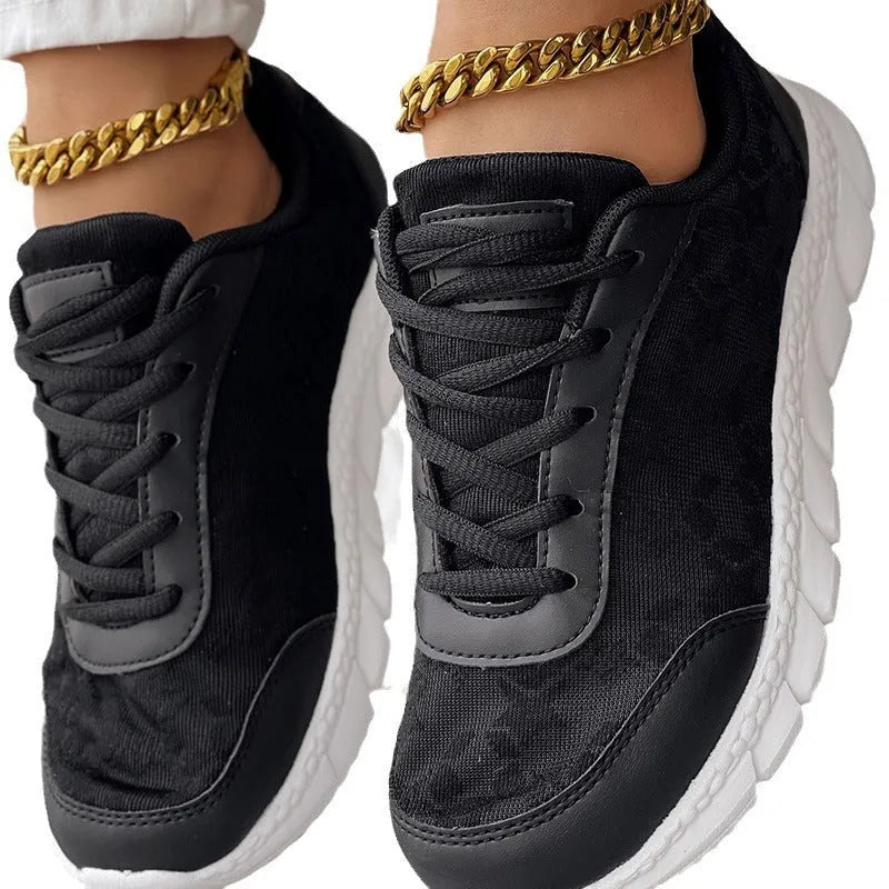 Women's white canvas sports shoes with flat heel and round toe design on neutral background