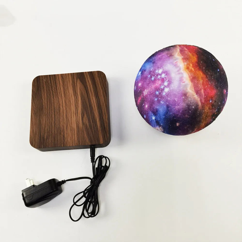 Magnetic levitation galaxy decorative light with rotating moon lamp above walnut-coloured base
