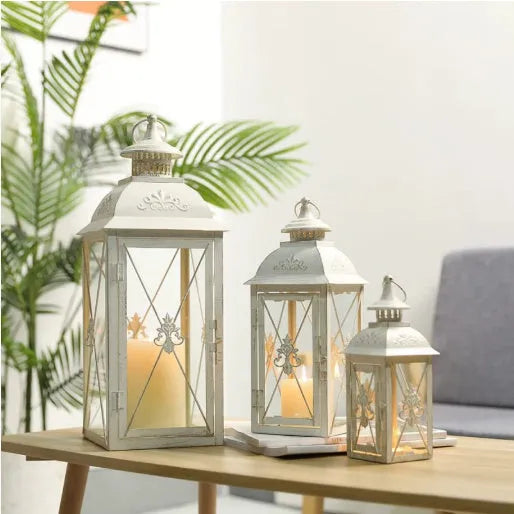 Black wrought iron floor lantern with tempered glass panels, standing on a patio.