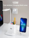 Modern black and white wireless charging desk lamp with integrated pen holder and storage compartment.