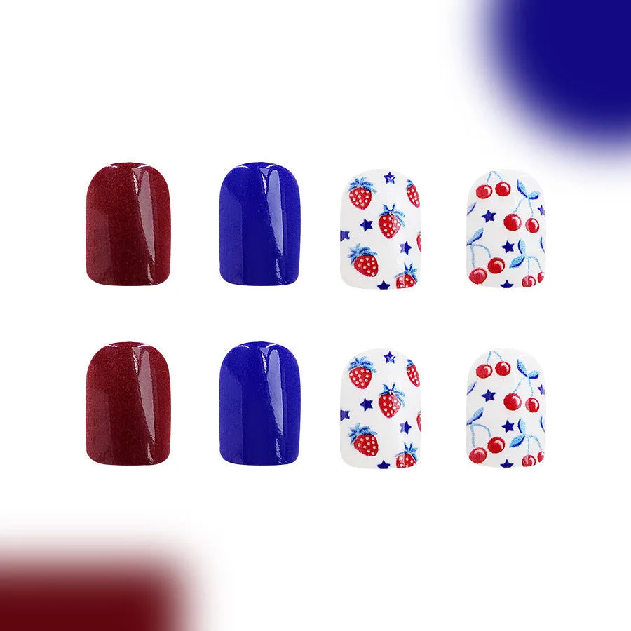 Short glossy false nails with strawberry cherry independence day patterns in red and blue