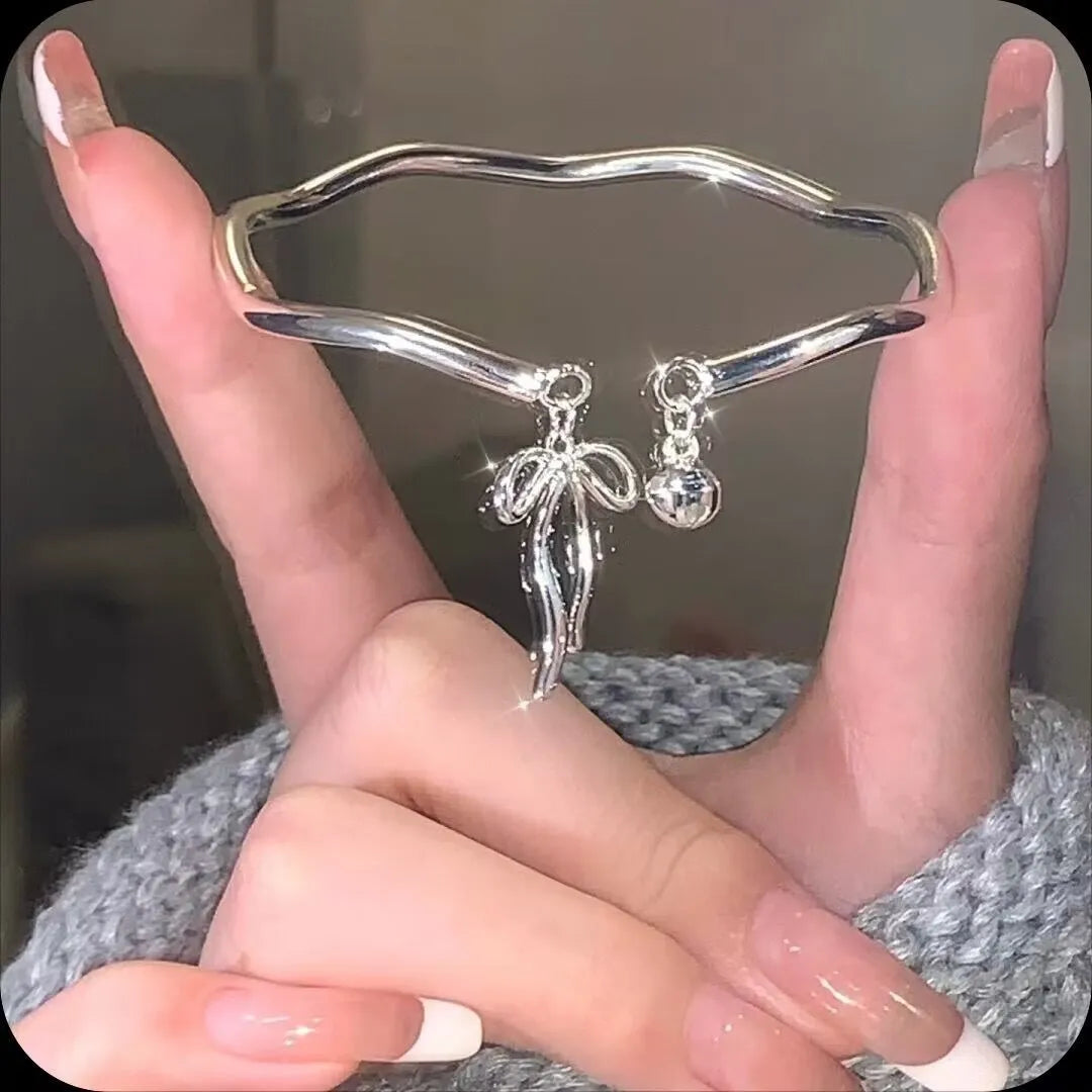 Silver adjustable women's bracelet with bow-shaped bell opening closure on zinc alloy chain