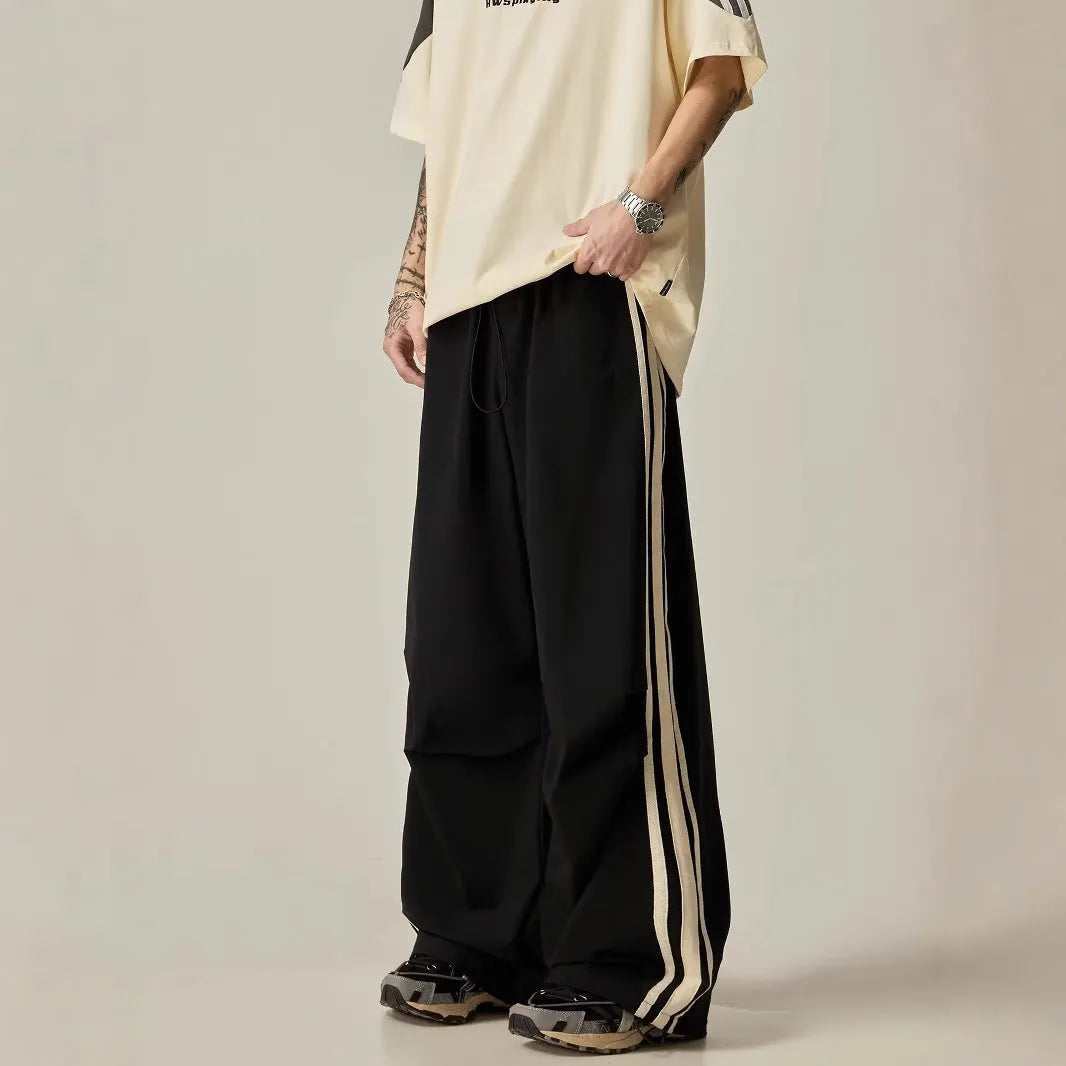 Men's black climbing trousers with high waist and wide straight leg design on hanger