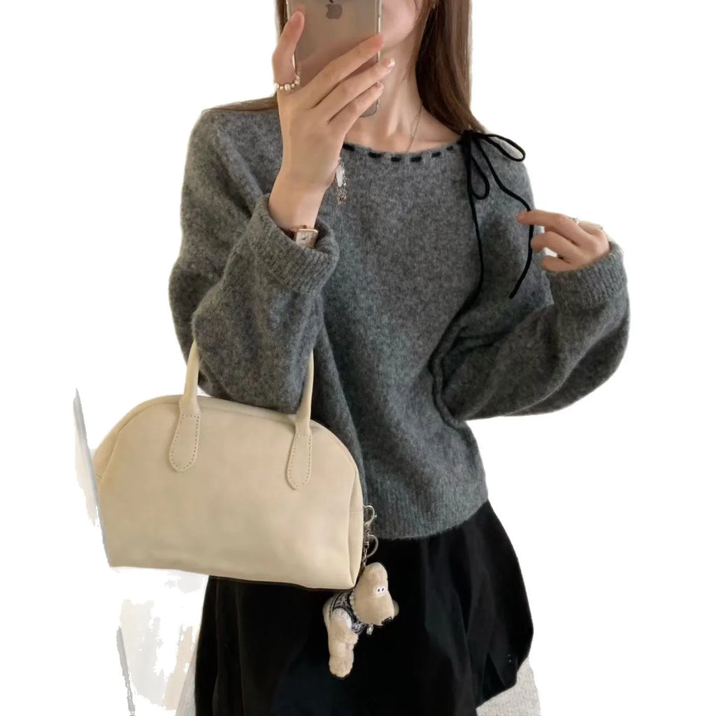 A grey loose-fitting women's knitwear pullover sweater on a hanger.
