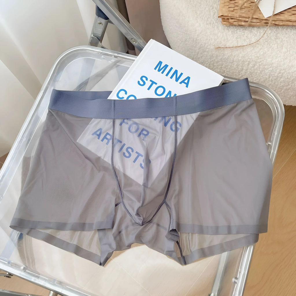 Man wearing thin grey knitted boxer shorts with a seamless, mid-waist design.