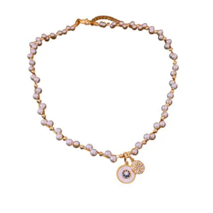 Gold electroplated zircon and imitation pearl round pendant on an adjustable clavicle chain necklace.