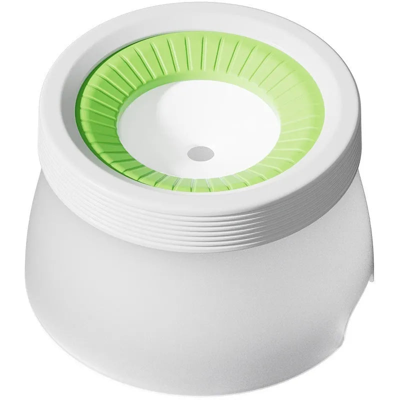 Green raised pet suspension bowl for dogs and cats on a white plate.