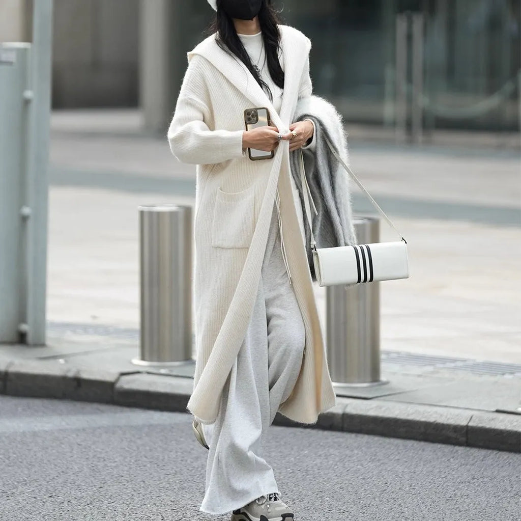 Long grey hooded knitted cardigan with a trench coat style on a hanger
