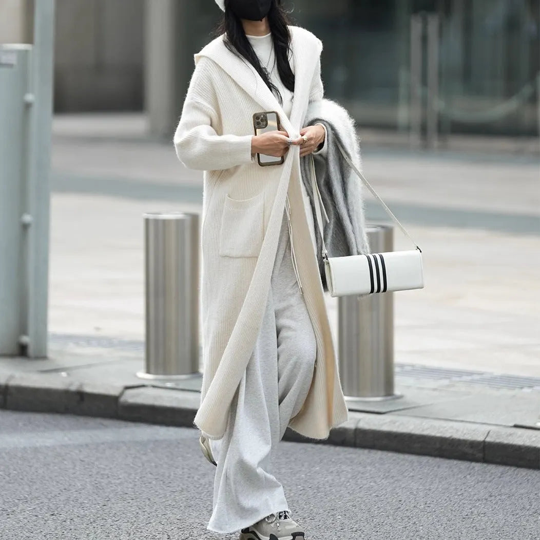 Long grey hooded knitted cardigan with a trench coat style on a hanger