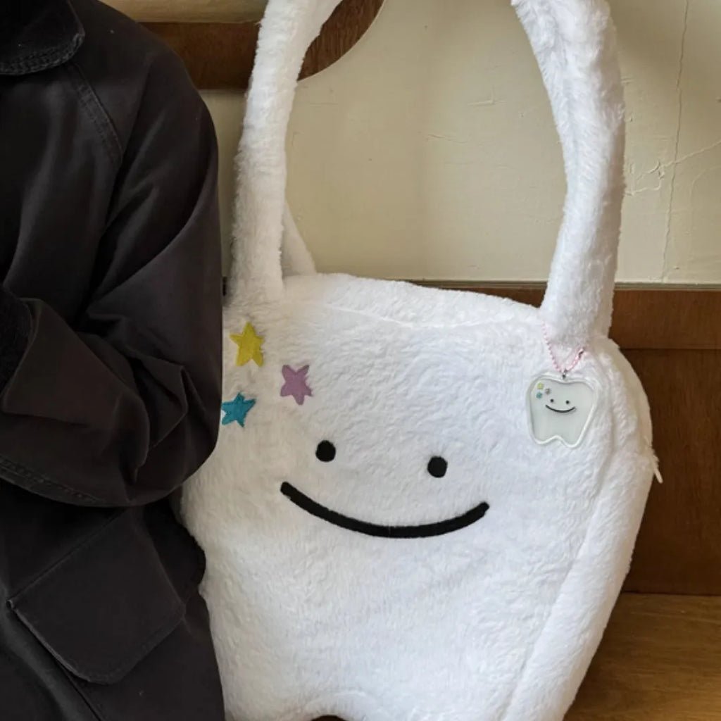 White plush large tooth shoulder tote bag with zip opening shown as crossbody carry