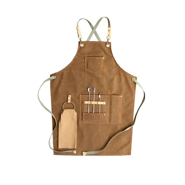 Canvas cross-back apron in camel colour on a mannequin, showing adjustable neck and waist ties
