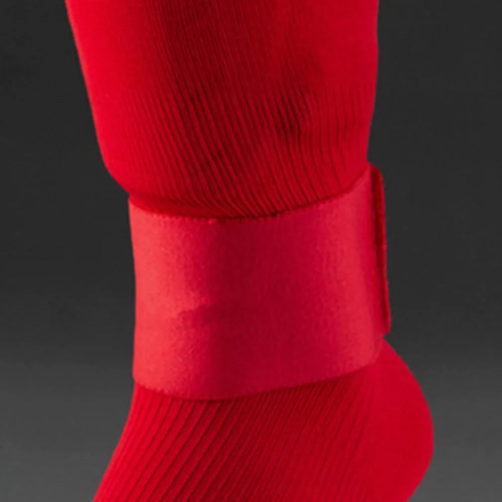 Red elastic rubber strap for securing football shin guards, shown next to shin pad