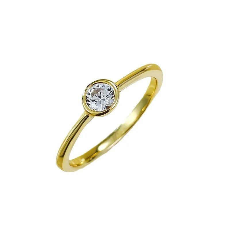 Minimalist crown shape silver ring electroplated in gold or platinum colour on a plain background.