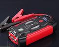 Red portable car emergency jump starter with digital display and thick clamps for 12V vehicle battery rescue