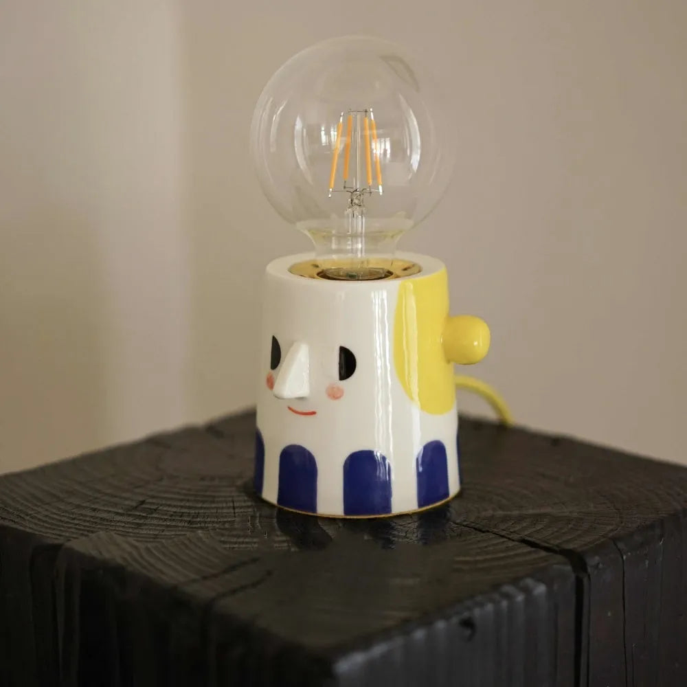 Handmade ceramic bedside lamp with spherical shade on wooden table