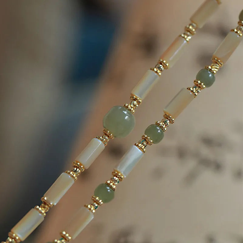 Natural Hetian jade white lip shell bracelet with geometric round beads on woman's wrist
