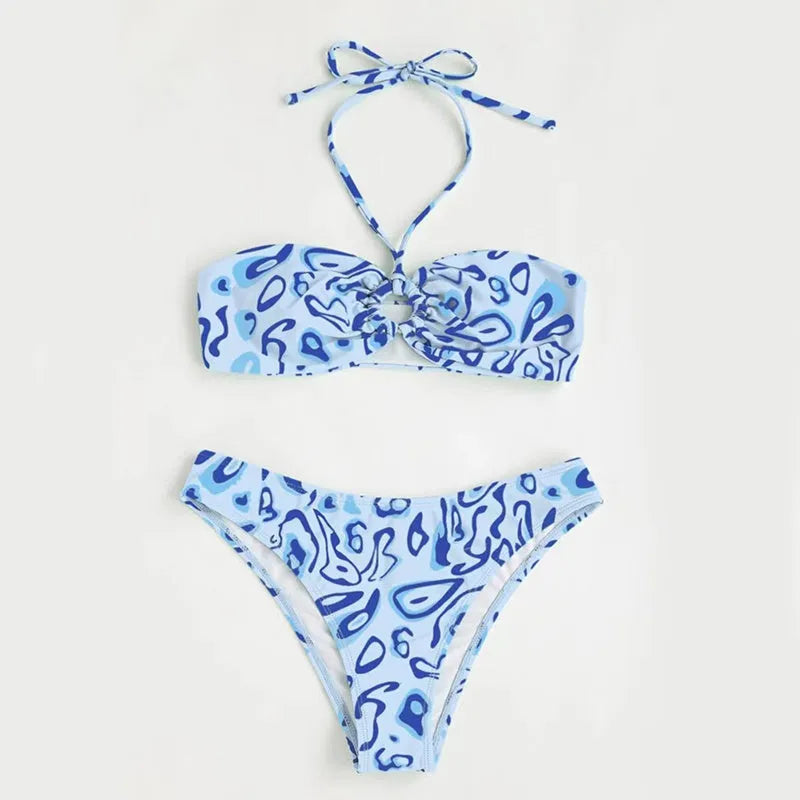 Women's blue floral bandeau bikini swimsuit with split design on beach background