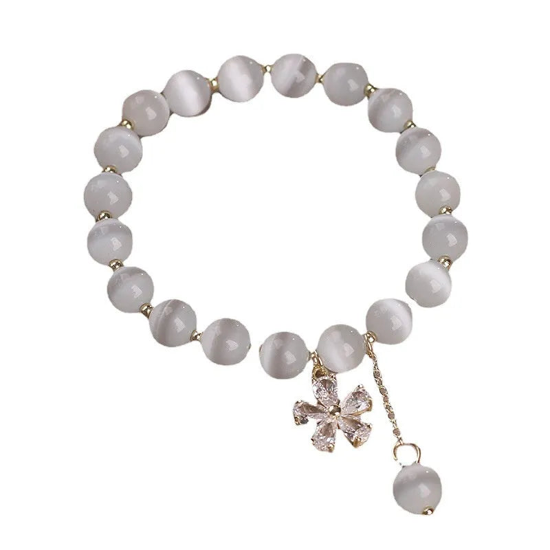 White cat's eye stone women's bracelet with flower tassel and morganite safety buckle pendant.