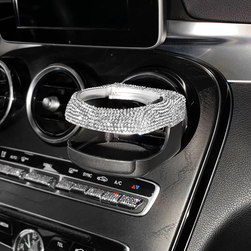 Sparkling rhinestone car cup holder bracket clipped to a vehicle air vent, shown in pink diamond colour.
