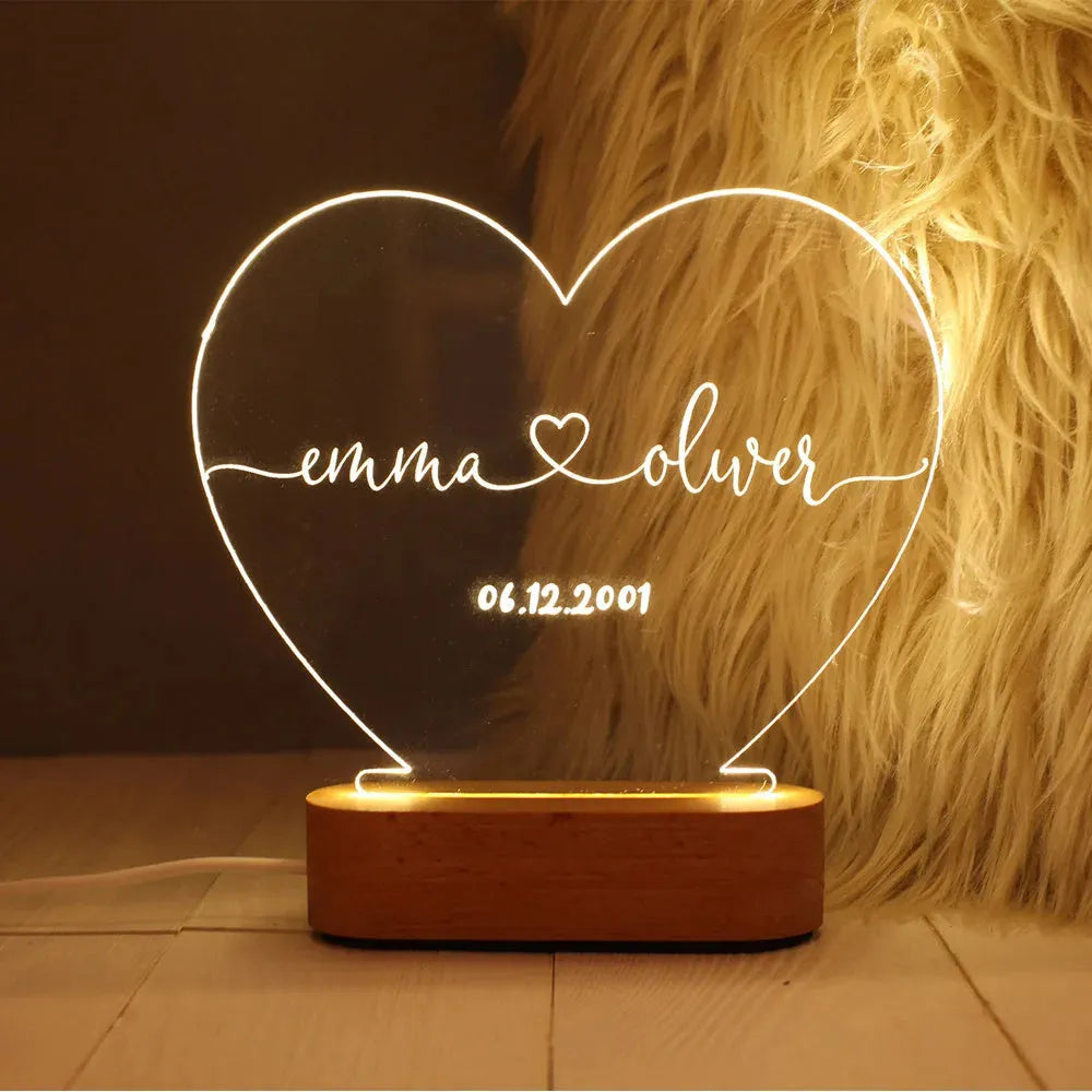 Custom clear acrylic night light with engraved names, lit by an LED base.