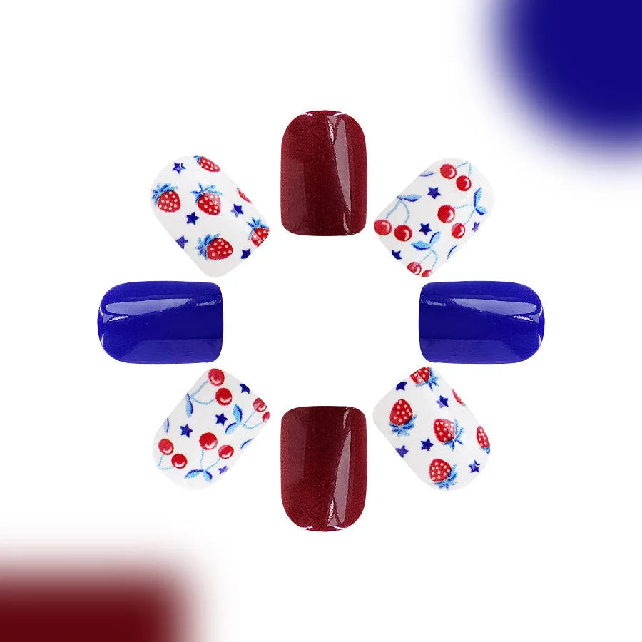 Short glossy false nails with strawberry cherry independence day patterns in red and blue