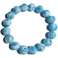 Blue natural crystal sea-pattern stone and bodhi seed bracelet with pearl accents on a wrist.