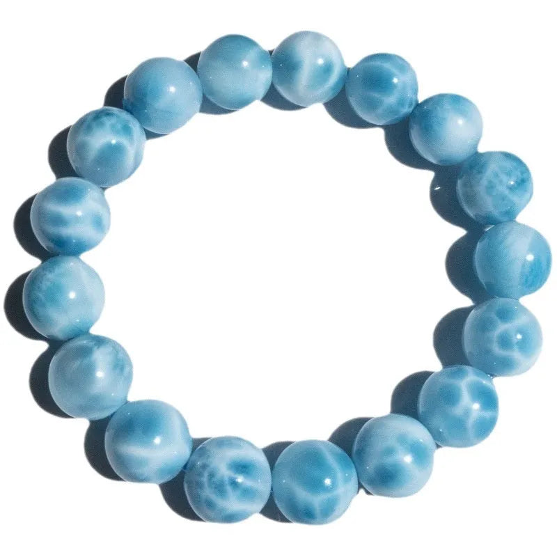 Blue natural crystal sea-pattern stone and bodhi seed bracelet with pearl accents on a wrist.
