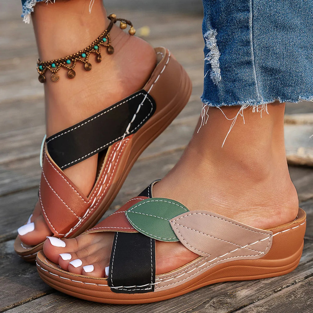 Black women's peep-toe slippers with a cross-strap design and a thick sole.