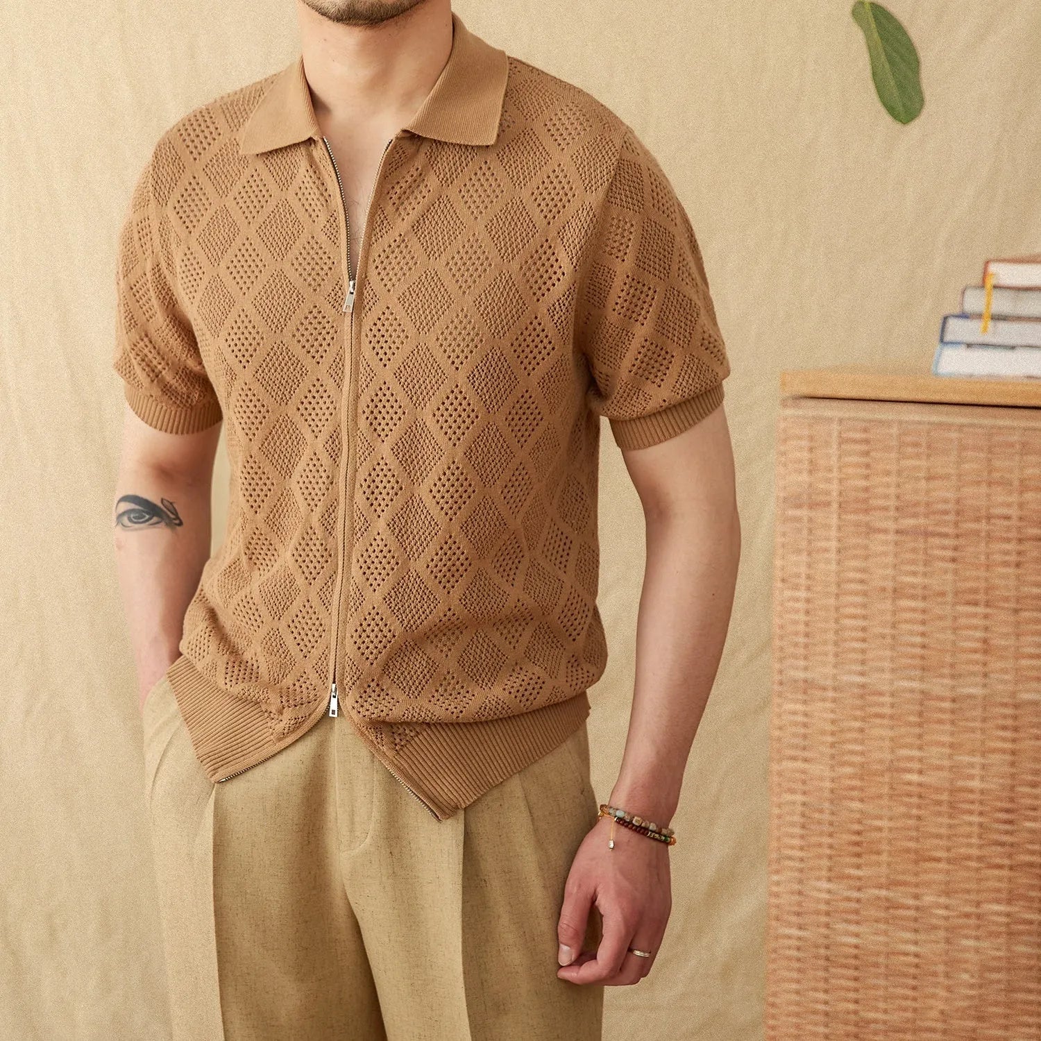 Man's light brown cotton cardigan with a front zipper, lapel collar, and short sleeves laid flat.