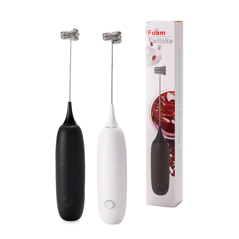 Black and white handheld electric milk frother with whisk attachment for coffee drinks