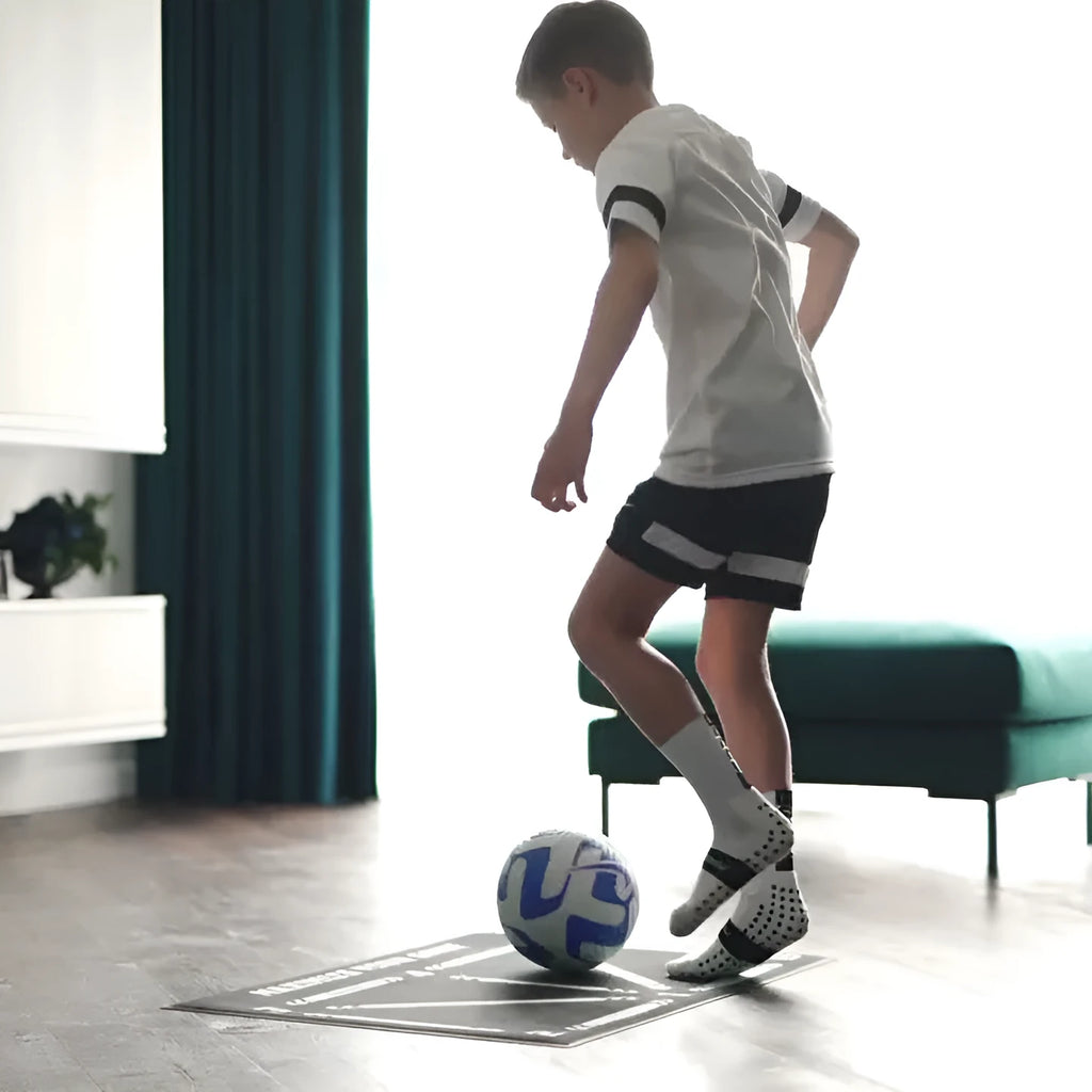 Black rectangular football training mat with non-slip surface measuring 60cm by 90cm