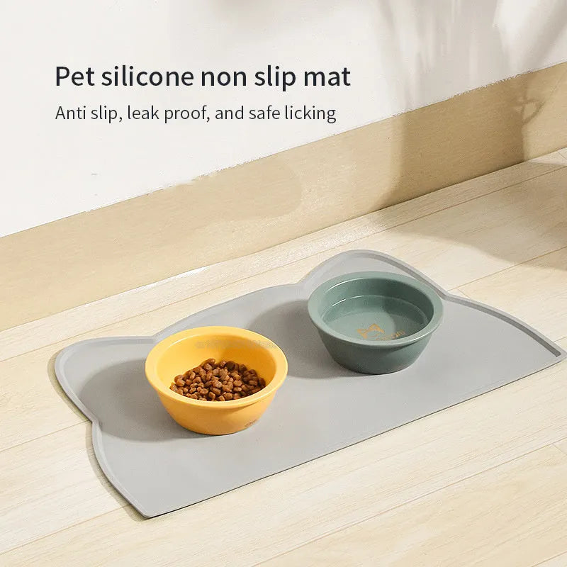 Blue silicone waterproof pet feeding mat for dog or cat food bowls on a wooden floor.