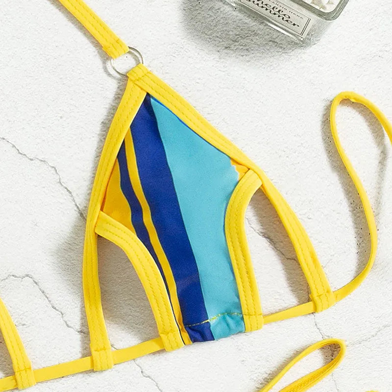 Yellow women's two-piece swimsuit with high-waisted shorts and a sleeveless, backless top on a neutral background.