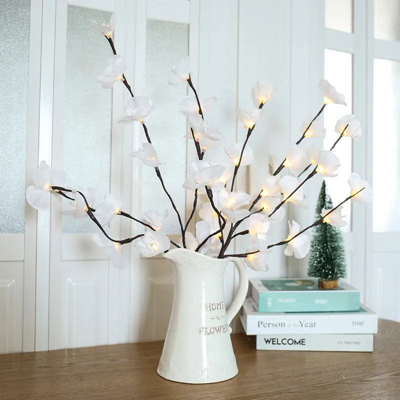 Pink LED phalaenopsis orchid branch decorative light on a dark surface.