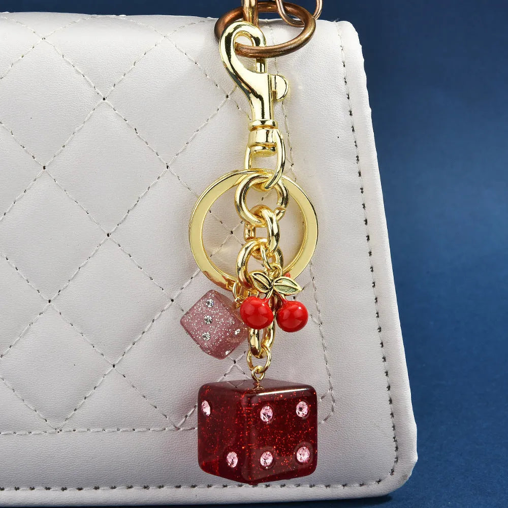 Square metal keychain pendant with a vintage cherry two-colour dice design.